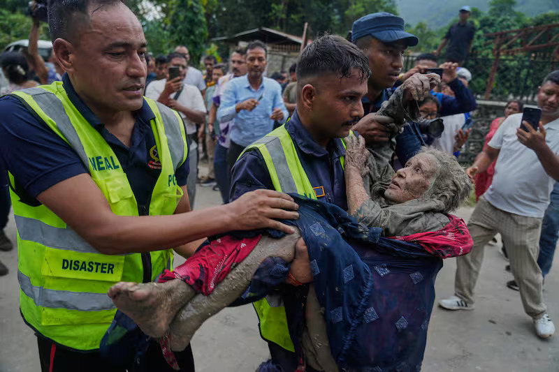 rescuers carry a victim of flash flooding to safety along th