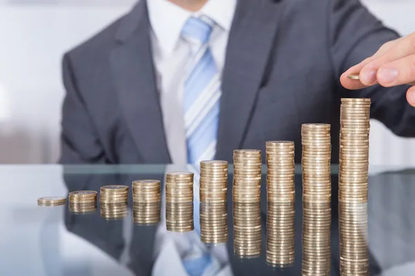depositphotos 42841769 stock photo businessperson with stack of coins